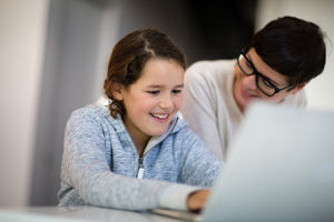 Daughter doing homework on laptop