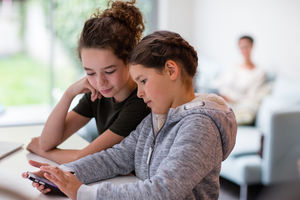 Sisters using smartphone together