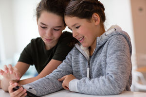 Sisters using smartphone together