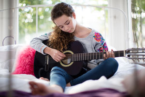 Teenager playing acoustic guitar