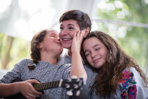 Daughters kissing and hugging Mum