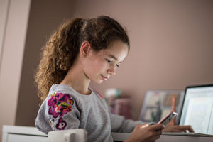 Teenager in bedroom looking at smartphone