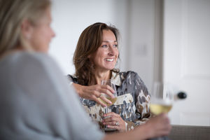 Mature female friends having a glass of wine