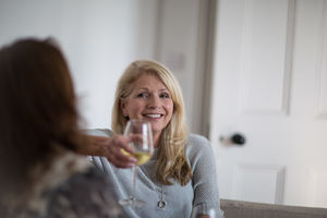 Mature female friends having a glass of wine