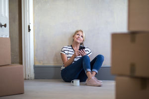 Mature female sitting with moving boxes