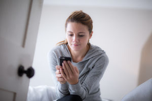 Young adult female checking smartphone in the morning