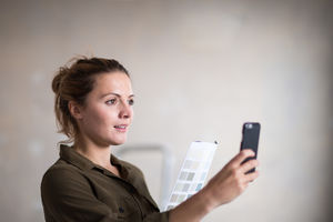 Young adult female choosing paint colors with the help of an app