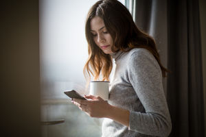 Young adult female checking smartphone in the morning