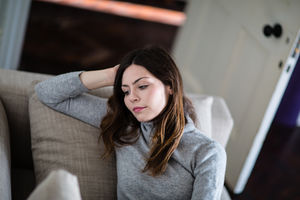 Young adult female relaxing on sofa at home