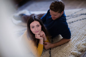 Couple lying on rug in new home