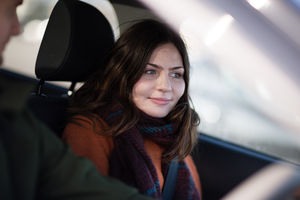 Passenger smiling at road ahead