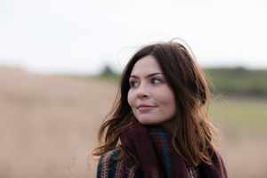 Young adult female walking in field of corn