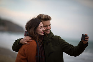 Young adult couple taking a selfie on beach