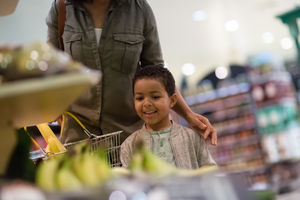 Boy looking at bananas in grocery store