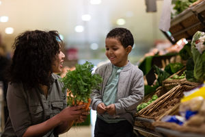 Boy picking carrots in grocery store