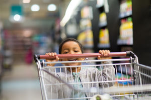 Young boy pushing trolley in grocery store