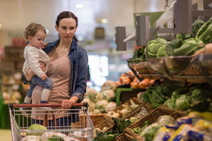 Mother and daughter buying vegetables in grocery store