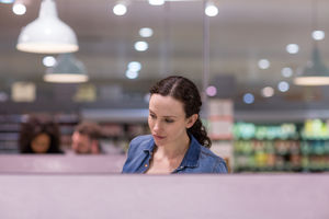 Woman looking at ready meal in grocery store