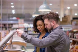 Couple choosing a ready meal in grocery store