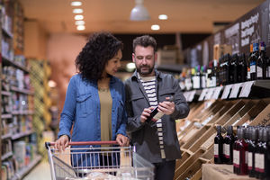 Couple choosing wine in grocery store