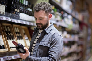 Man choosing wine in grocery store
