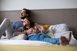Young couple having tea in bed
