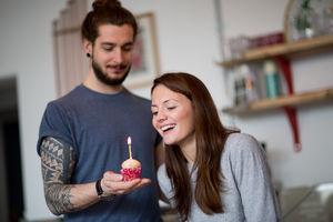 Boyfriend giving girlfriend a birthday cupcake