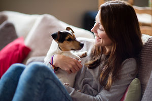 Young female with puppy at home