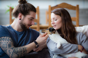 Young couple with pet puppy Jack Russell