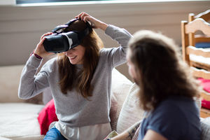 Young adult female putting on VR headset