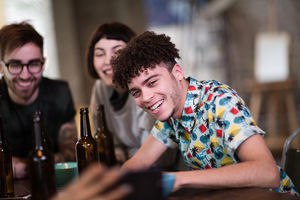 Group of friends looking at a smartphone together in a pub