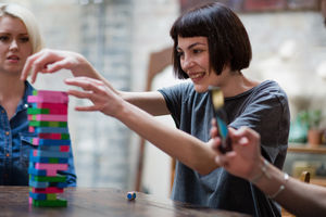 Group of friends playing retro game in pub