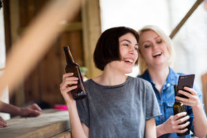 Two friends at a street food bar drinking beer