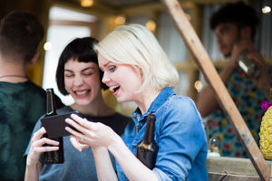 Two friends at a street food bar drinking beer