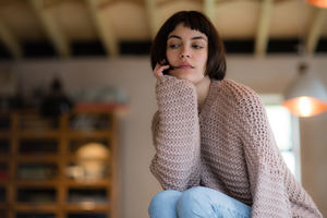 Young adult female looking thoughtful at home