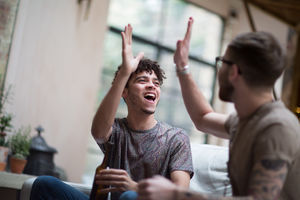 Two male friends giving high five