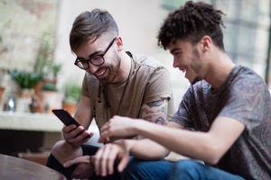 Two male friends looking at a smartphone