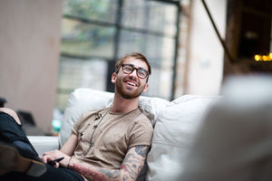 Young adult male laughing at home