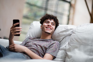 Young adult male laughing at home