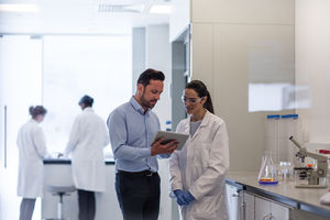 Female scientist discussing data with pharmaceutical sales rep