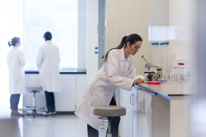 Female scientist looking at microscope