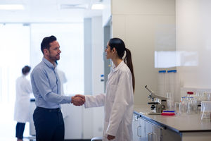 Female scientist shaking hands with pharmaceutical sales rep