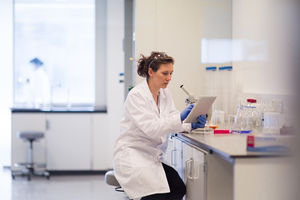 Female scientist looking at results of experiment on digital tablet