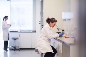 Female scientist looking through microscope