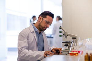 Male scientist looking at results of experiment on digital tablet