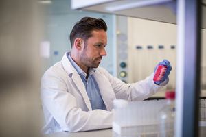 Male scientist looking at microplate in a laboratory