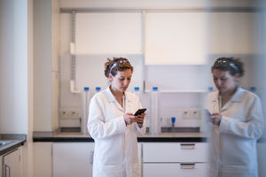 Female scientist using smartphone in laboratory