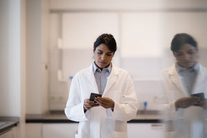 Female scientist using smartphone in laboratory
