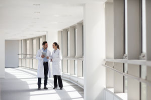 Two medical professionals discussing results on digital tablet