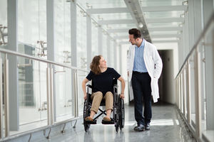 Woman in wheelchair talking with medical professional